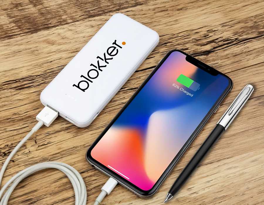 A white power bank charging a mobile phone
