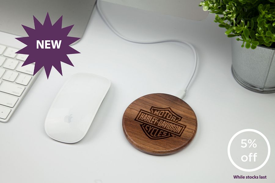 Walnut coloured wooden wireless charger on a desk